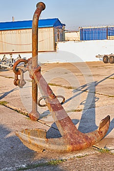 Old rusty two-legged anchor in the seaport