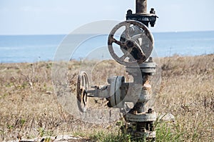 Old rusty valve closeup at seashore