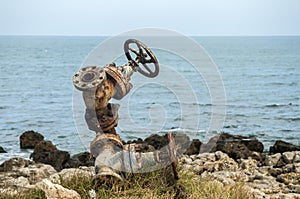 Old rusty valve closeup at seashore