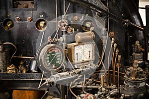 Old rusty valves, pipes, and gauges on an antique steam engine