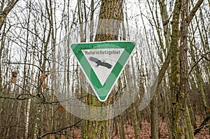 old rusty vintage forgotten german sign in forest translation naturschutzgebiet means nature reserve photo