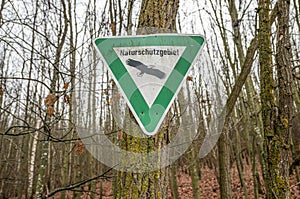 old rusty vintage forgotten german sign in forest translation naturschutzgebiet means nature reserve photo