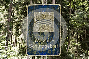 Old rusty vintage forgotten german sign in forest translation wasser schutzgebiet means water reserve