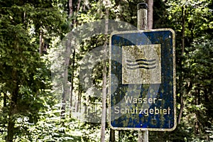 Old rusty vintage forgotten german sign in forest translation wasser schutzgebiet means water reserve