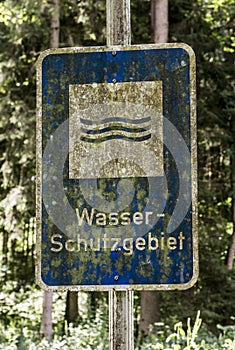 Old rusty vintage forgotten german sign in forest translation wasser schutzgebiet means water reserve