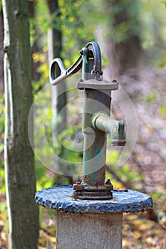 Old rusty water pump in a forest