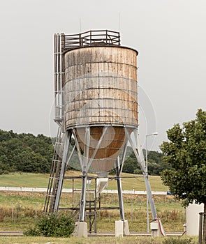 Old rusty water tank against clear blue sky