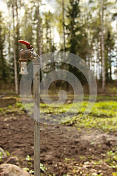 Old rusty water tap in a garden. Garden tap at the summer house