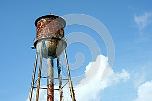 Old rusty watertower against blue sky photo