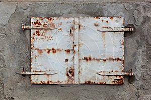 Old, rusty and weathered metal window coverings, closed shut