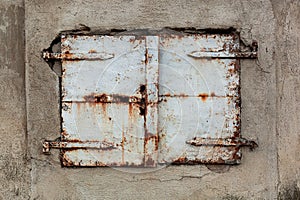 Old, rusty and weathered metal window coverings, closed shut