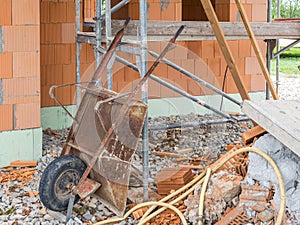 Old rusty wheelbarrow while building a house