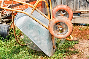 Old rusty wheelbarrow cart in the garden
