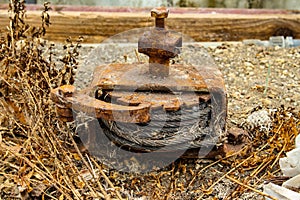 Old rusty winch with ratchet and pawl mechanism and a steel cable rolled up inside photo