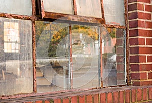 Old rusty window in warehouse reflecting fall