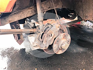 Old rusty worn brake discs, pads of a truck, car. Car suspension repair. Replacing wheel