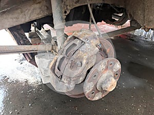 Old rusty worn brake discs, pads of a truck, car. Car suspension repair. Replacing wheel