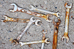Old rusty wrenches a cement background. Mechanic repair tools