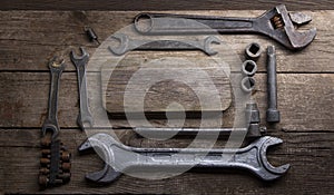 Old rusty wrenches on a wood table, top view