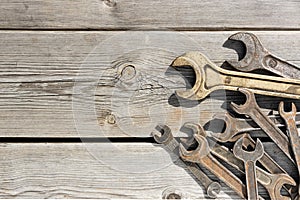 Old rusty wrenches on a wooden table