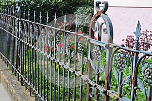 Old rusty wrought iron fence at a garden