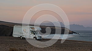 Old RV camper time lapse on La Pared, Fuerteventura, Canary Islands, with view of mountain and ocean