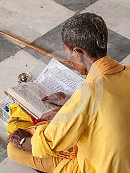 Old sadhu reading scriptures