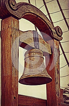 Old sailing ship bell on grunge texture photo