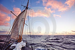 Old sailing ship mast at sunset.