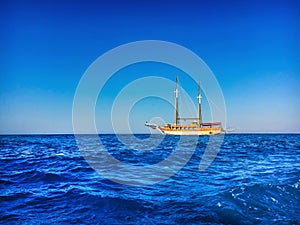 Old sailing yacht on a background of blue sea and blue sky