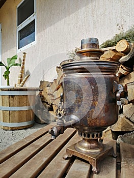 Old samovar on the background of firewood