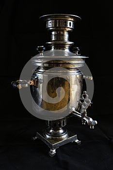 An old samovar isolated on a black background.Russian samovar.Metal vessel for boiling water and making tea.