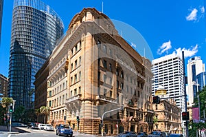 Old sandstone building with modern skyscrapers on the background