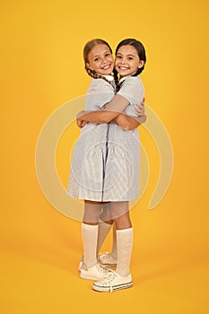 Old school. kid fashion. happy friends embrace on yellow background. fashion beauty. childhood happiness. sisterhood of