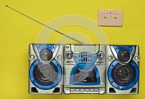 Old school retro tape recorder and audio cassette on a green background. Obsolete technologies. Trend of minimalism. Top view.