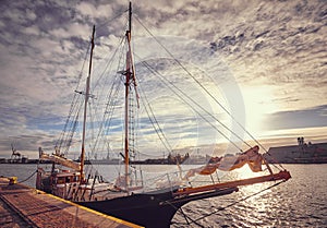 Old schooner moored in a harbor at sunrise.