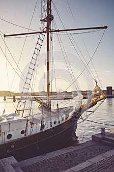 Old schooner moored to a pier in Copenhagen at sunset