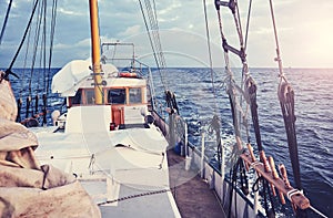 Old schooner sailing at sunset, color toning applied