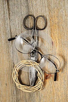 old scissors, glasses and hank of packthread on wooden background