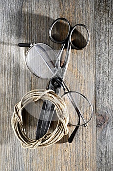 old scissors, glasses and hank of packthread on wooden background