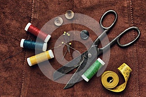 Old scissors and sewing objects on a natural suede background