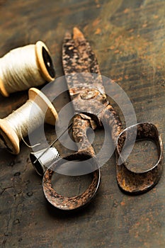 An old scissors with sewing threads
