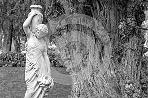 An old sculpture of a woman carrying a water pitcher in black and white