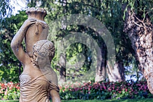 An old sculpture of a young woman carrying a water pitcher.