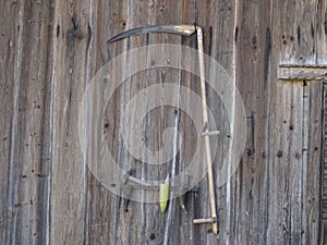 Old scythe on a wood wall