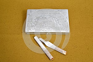 Old self-made cigarette case of a wartime and two cigarettes