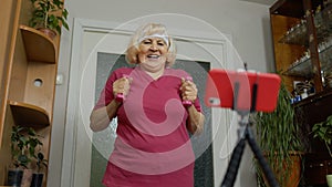 Old senior grandmother woman doing workout with dumbbells, training, fitness, sport activity at home