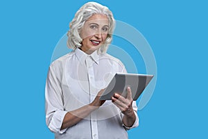 Old senior gray-haired woman with tablet pc.