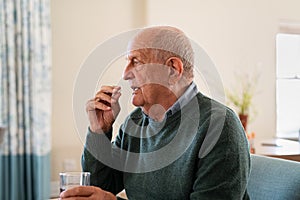 Old senior man taking medicine pill