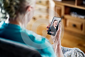 Old senior woman having a phone video call with young lady. Family communication. Mobile technology. Grandma using smartphone.